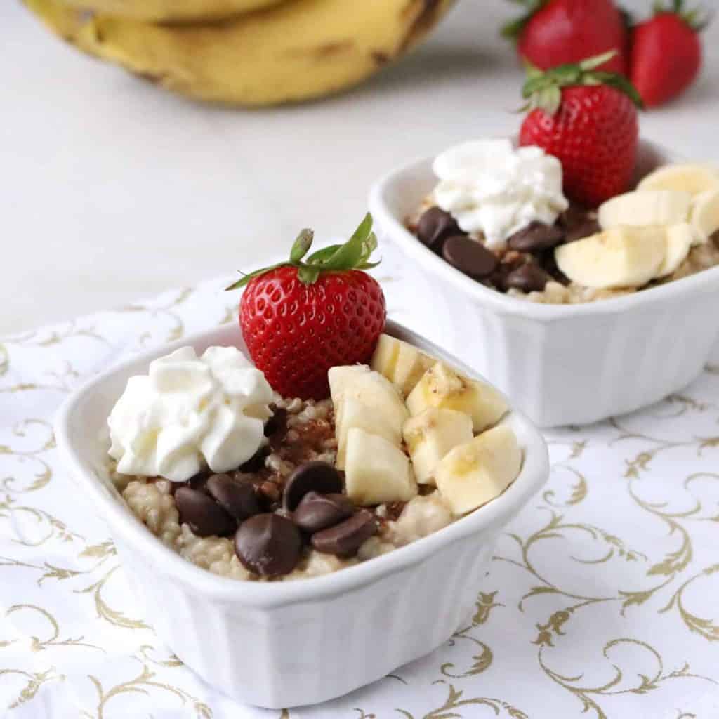 Instant Pot Banana Split Oatmeal in 2 bowls with bananas in the background.