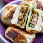 Vegan Bao Buns on a purple plate with one cut in half.