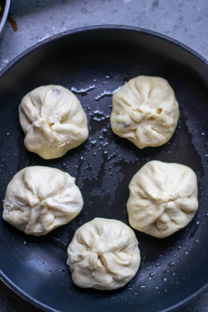 Vegan Bao Buns cooking in a frying pan.