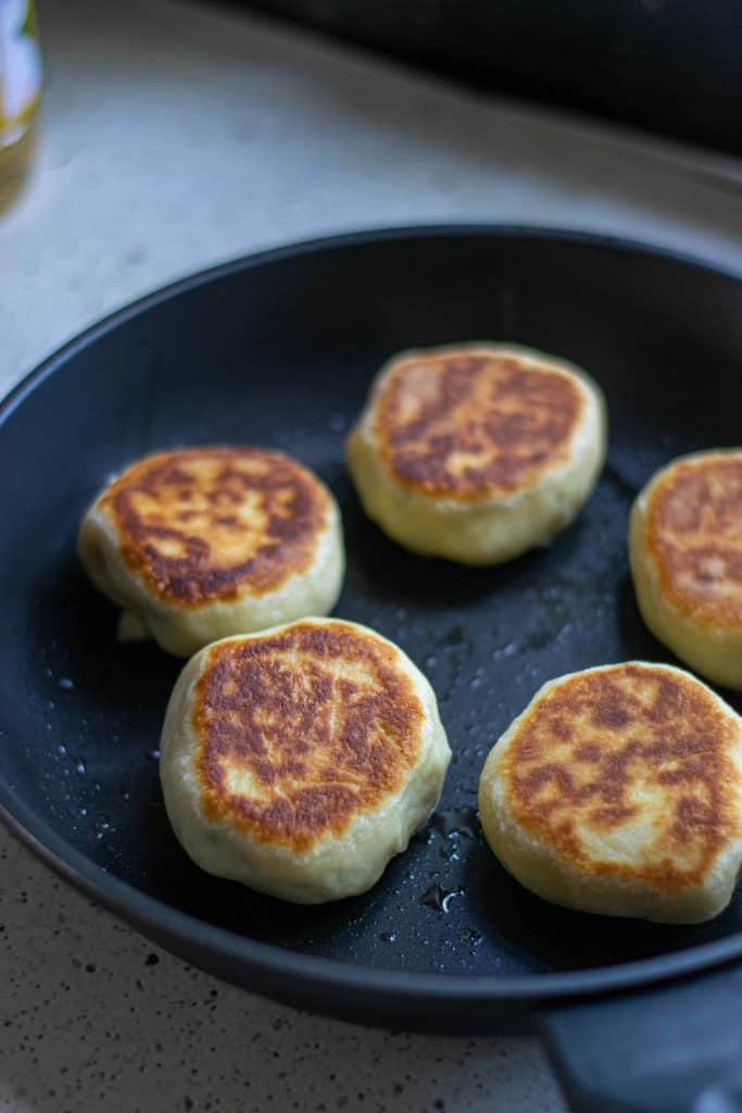 Fried vegan bao buns in a skillet.