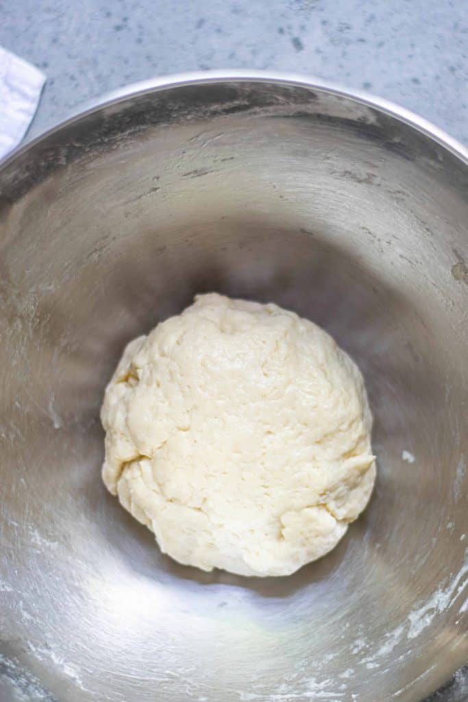 Dough ball in a stainless steel bowl.