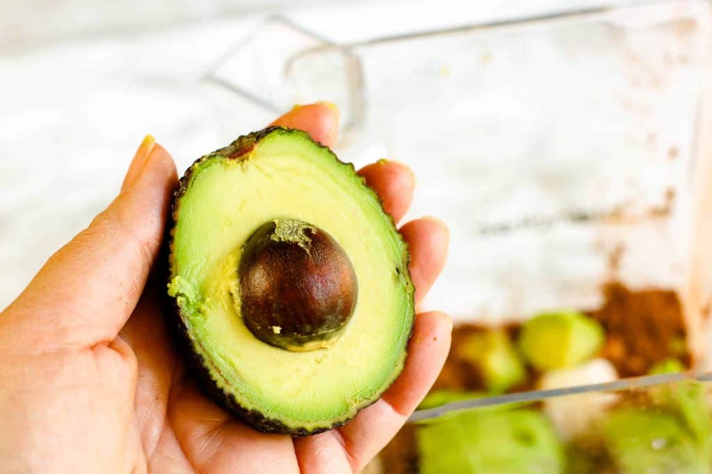 Half of an avocado with pit still in tact.