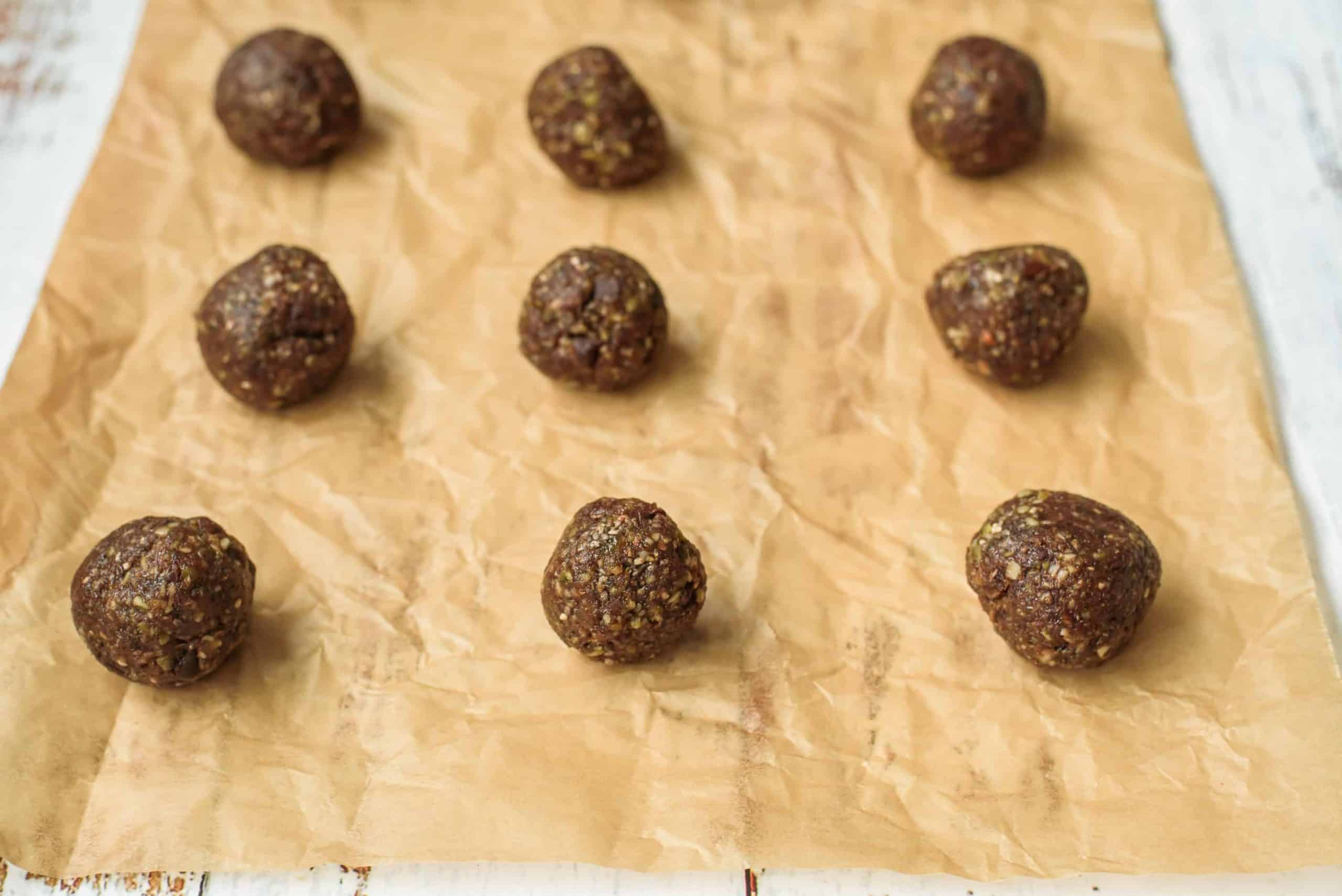 Closeup of Peanut Butter Crunch Balls on Parchment lined Baking pan.