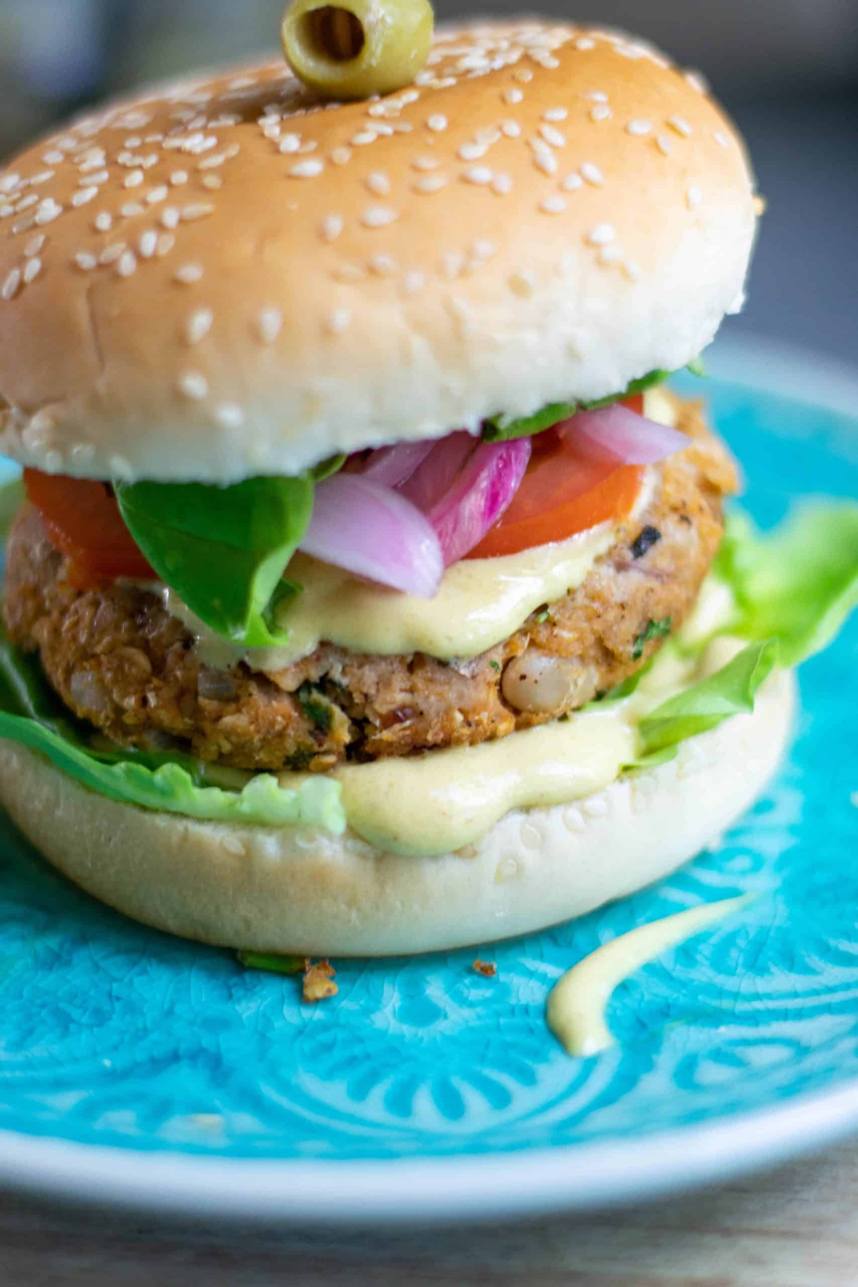 Angled photo of white bean burger on a blue plate.