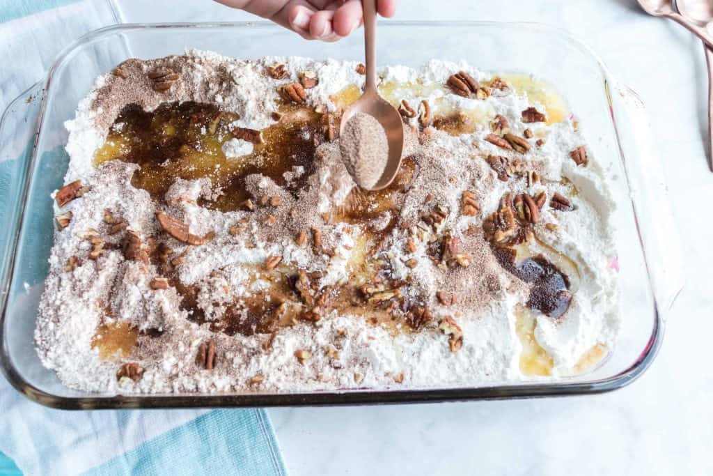 cinnamon sugar being sprinkled on top of cake butter.