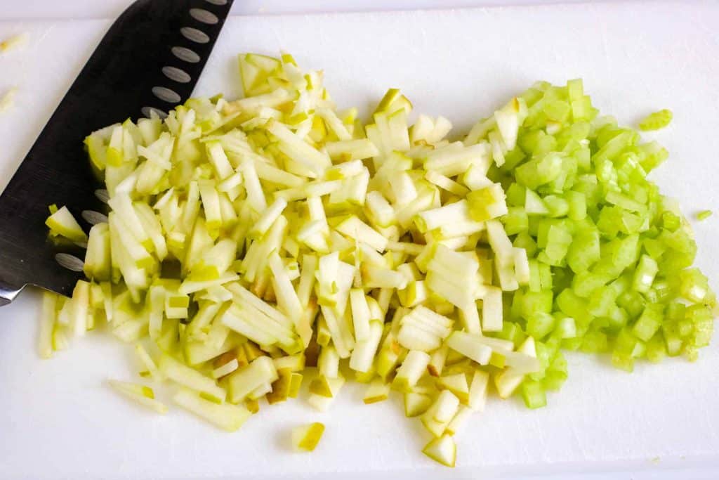 Chopped apples and celery on a cutting board.