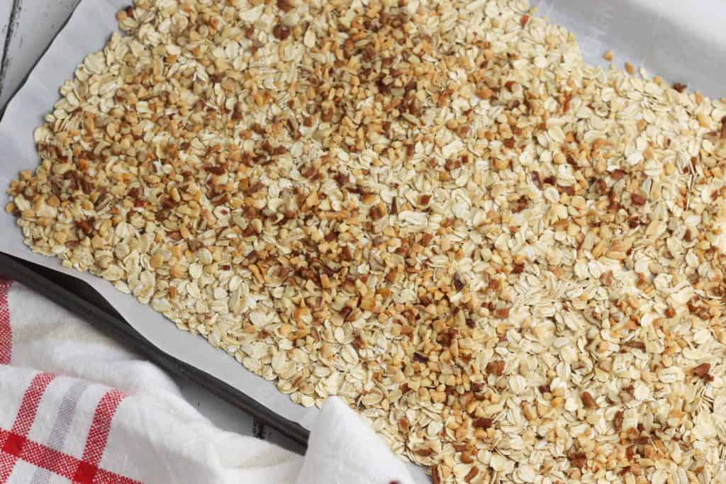 Rolled oats baked on a baking sheet lined with parchment paper.