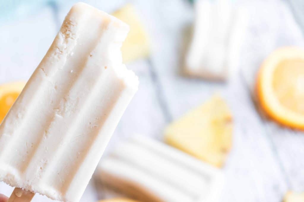 Closeup of popsicle with a bite out of the top of it.