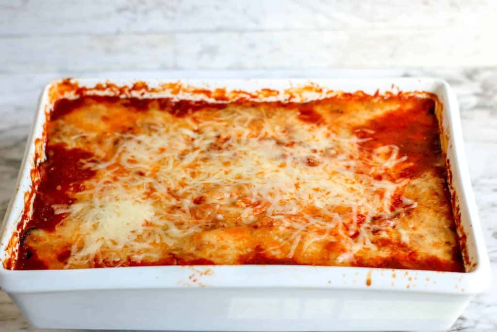 Baked eggplant in white ceramic baking dish.