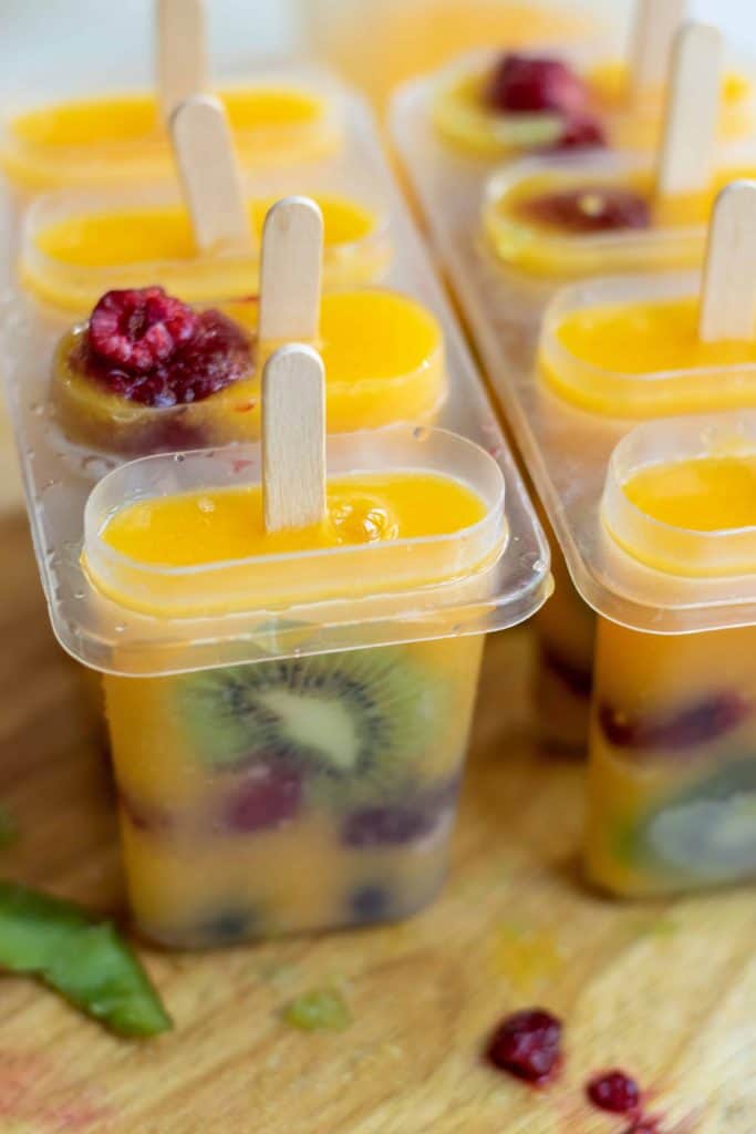 Kiwi mango and berry popsicles in mold ready for freezer.