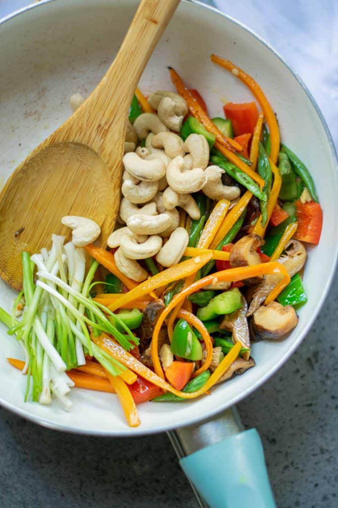 cashews and vegetables in a saut&eacute; pan.