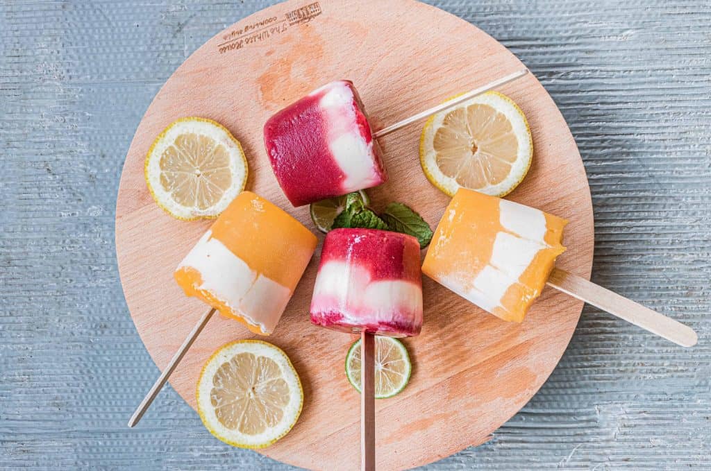 Yogurt popsicles on a round, wood board