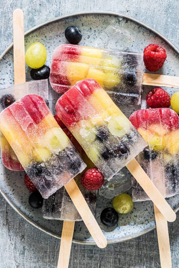 Rainbow popsicles on a plate.