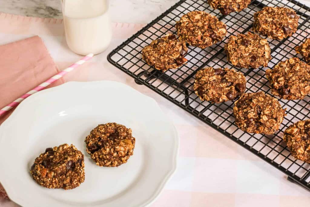 Banana Bread Cookies on a cooling rack and two on a white plate.