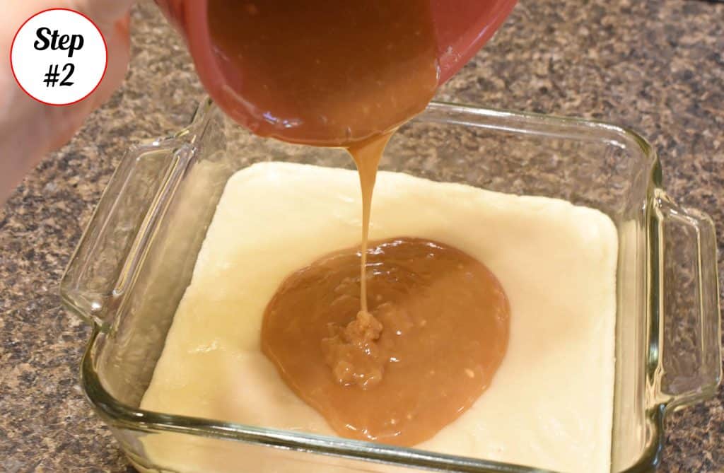 Caramel sauce being poured on top of cookie dough.