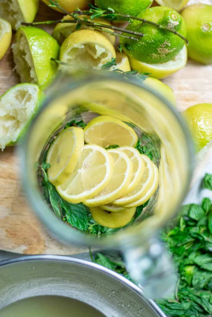 Overhead view of lemon slices in a glass pitcher.