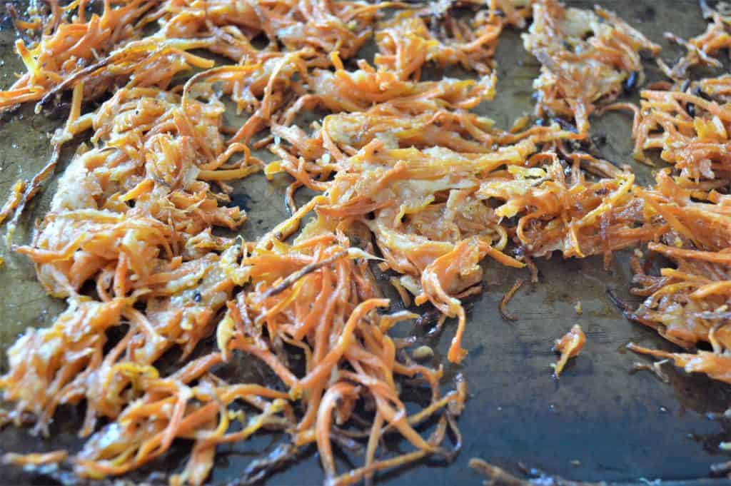 Cheesy shoestring carrot fries on a roasting pan.
