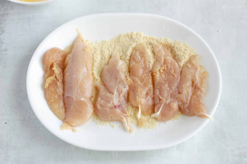 Chicken tenders on a white plate.