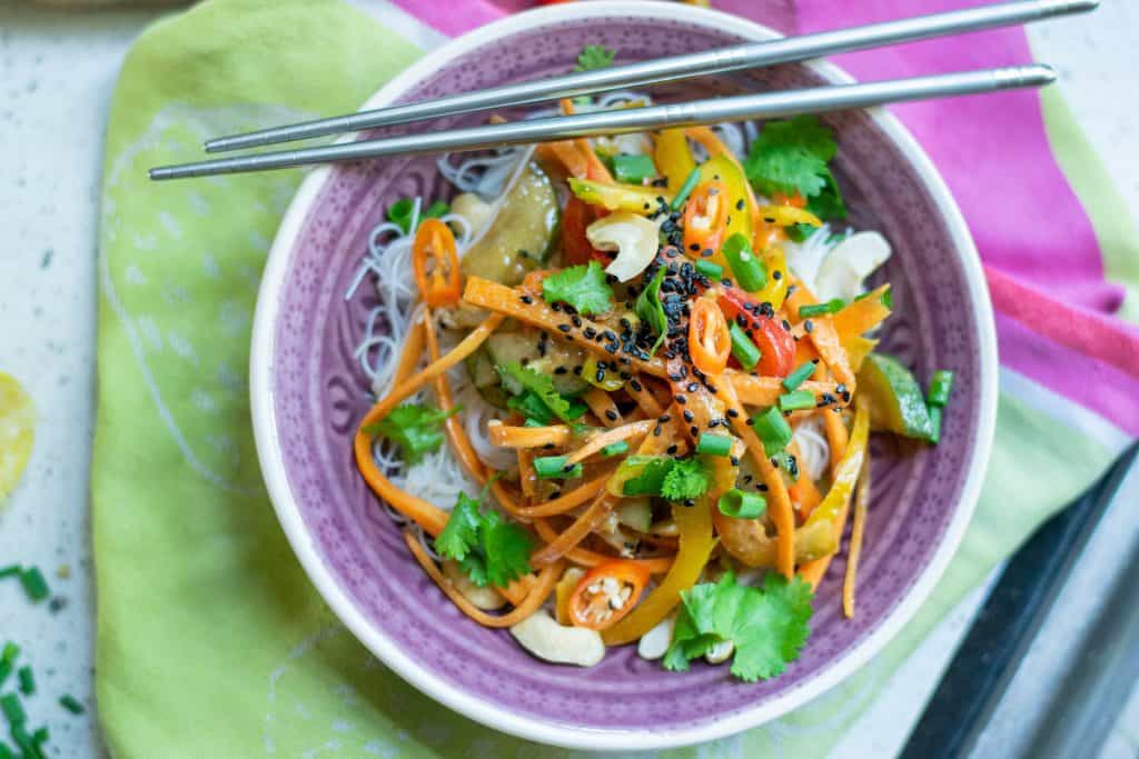 Overhead shot of Thai Peanut Salad in a purple bowl with chopsticks on the top.