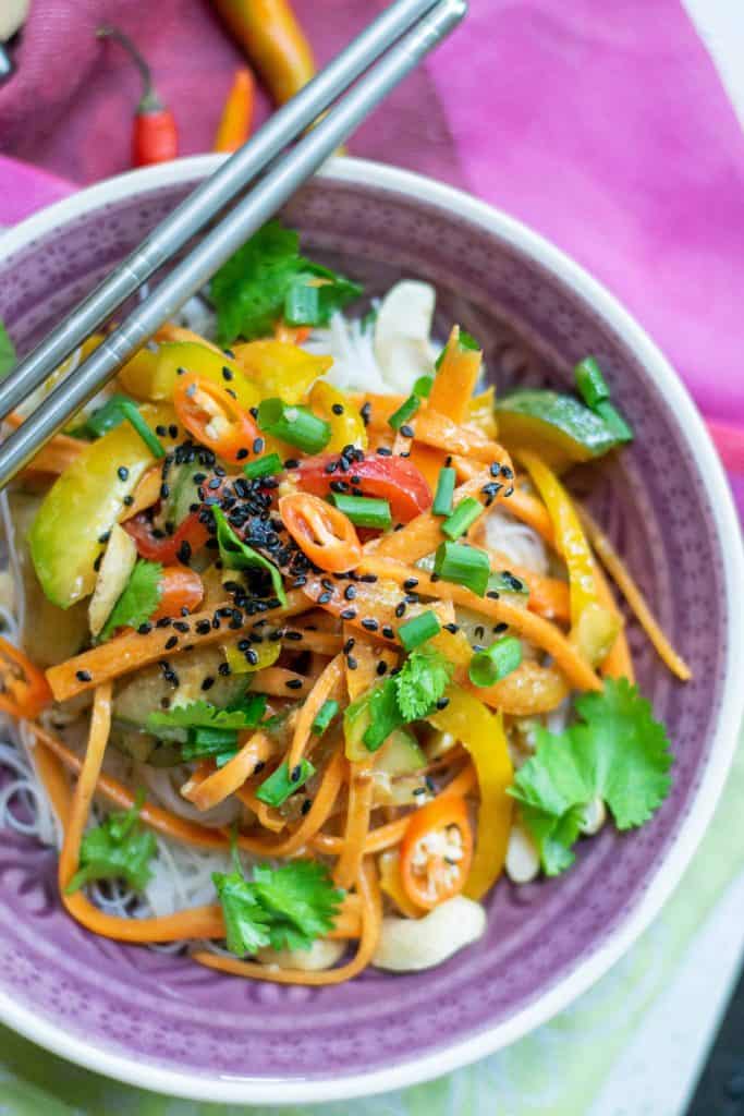 Overhead closeup shot of Thai Peanut Salad in a purple bowl with metal chopsticks on the side.