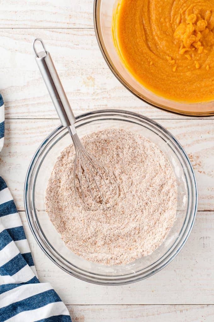 Dry ingredients for pumpkin muffins in a glass bowl.