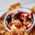 closeup of cinnamon tortilla chip with fruit salsa on it.