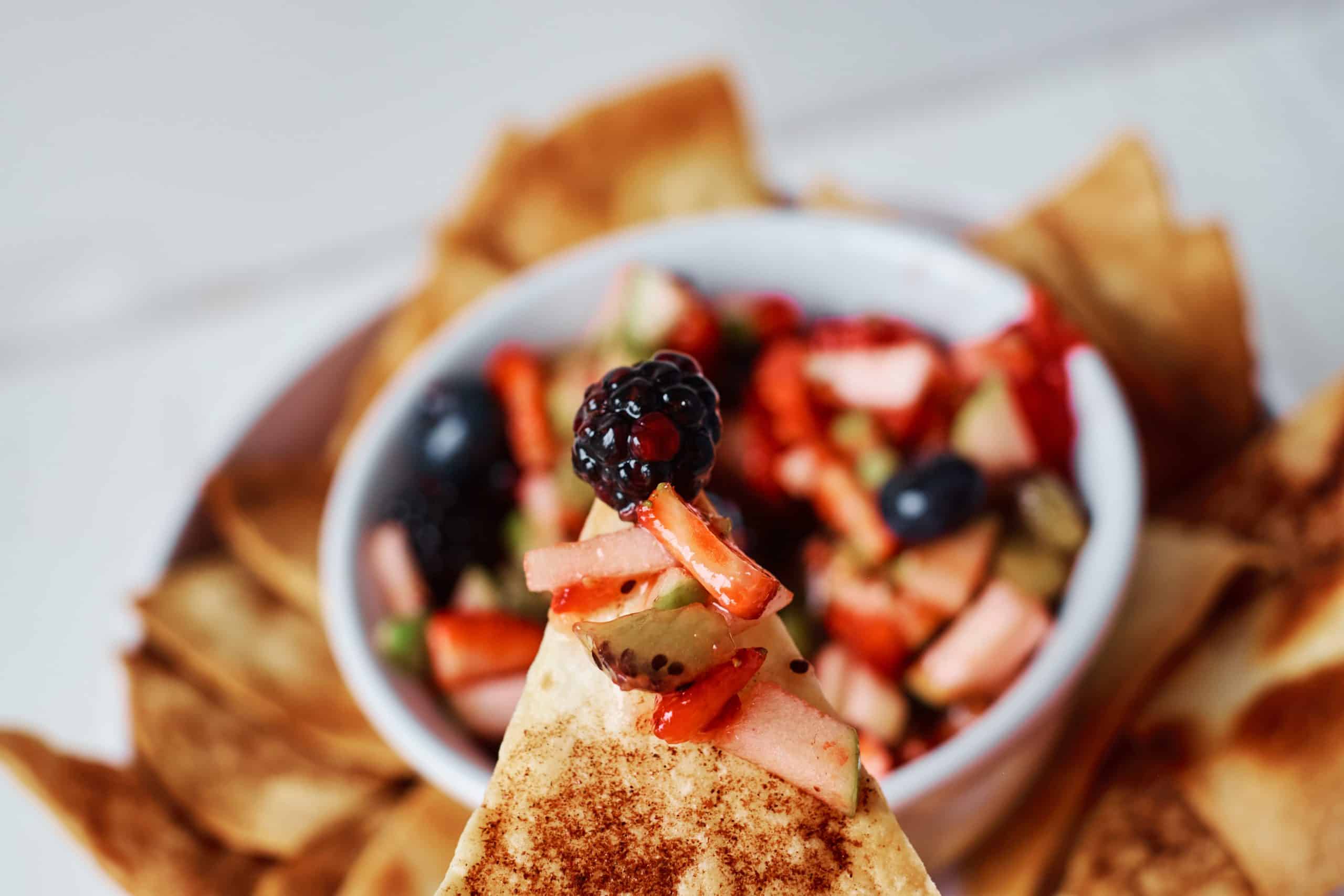 closeup of cinnamon tortilla chip with fruit salsa on it.