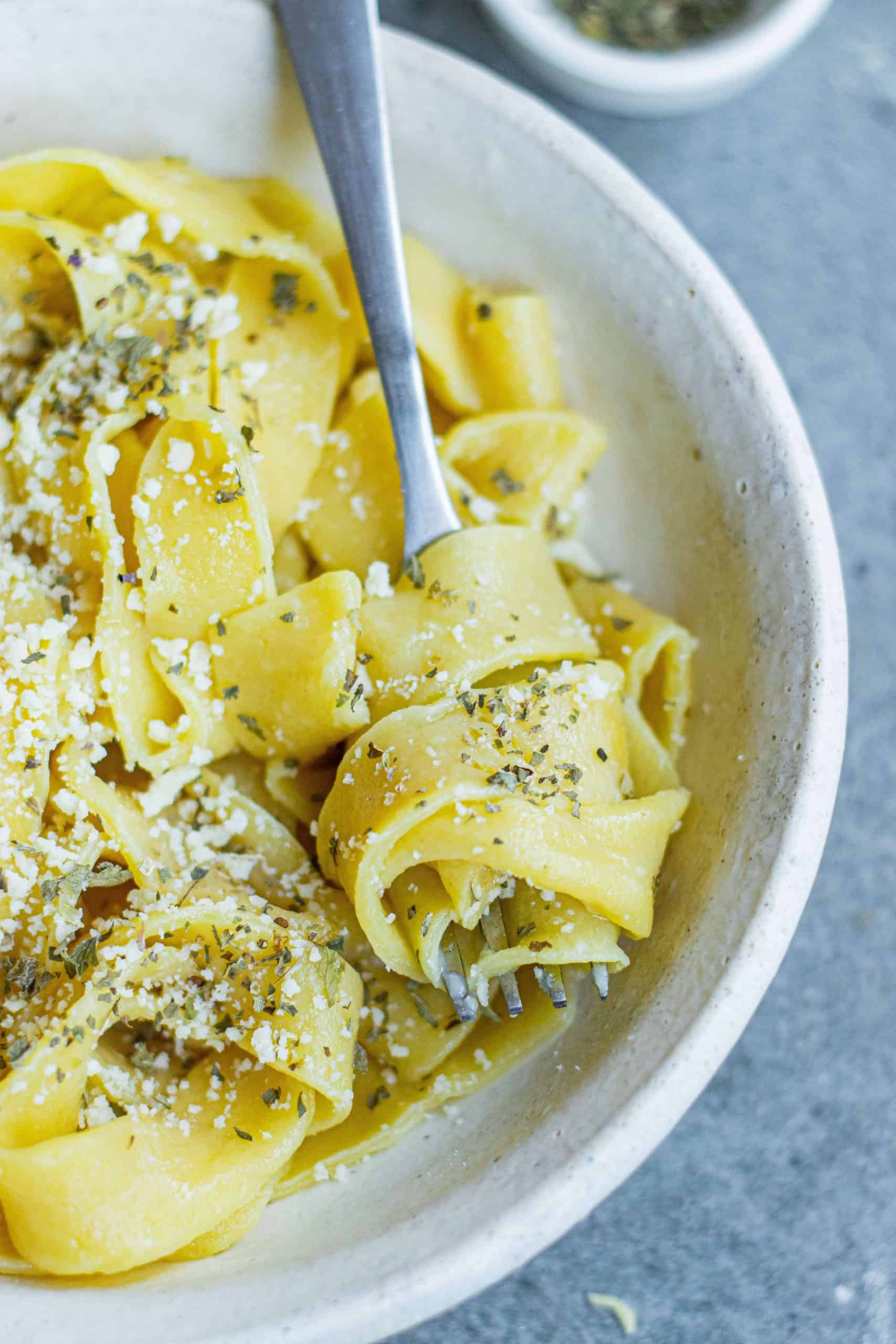 Closeup of spaghetti on a fork with seasonings.