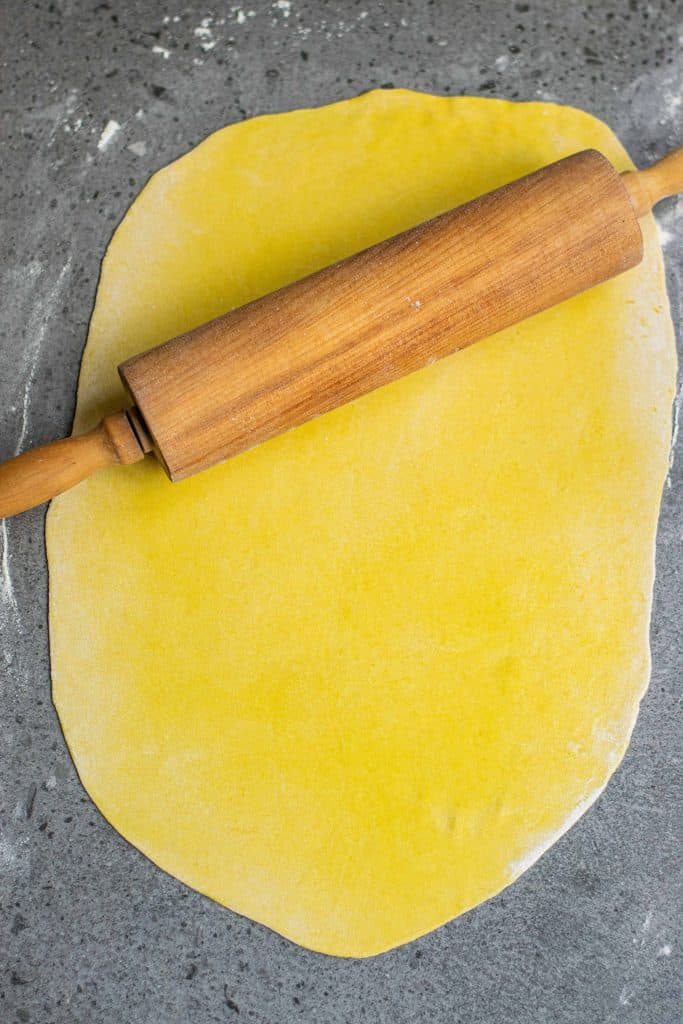Pasta dough rolled flat with a rolling pin.