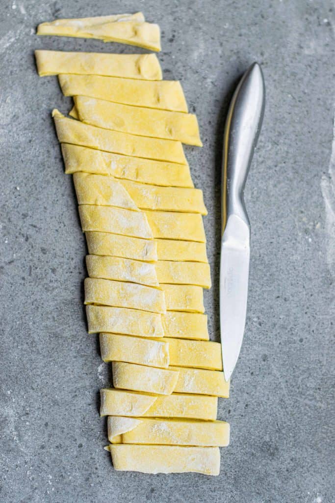 Cutting pasta dough into strips.