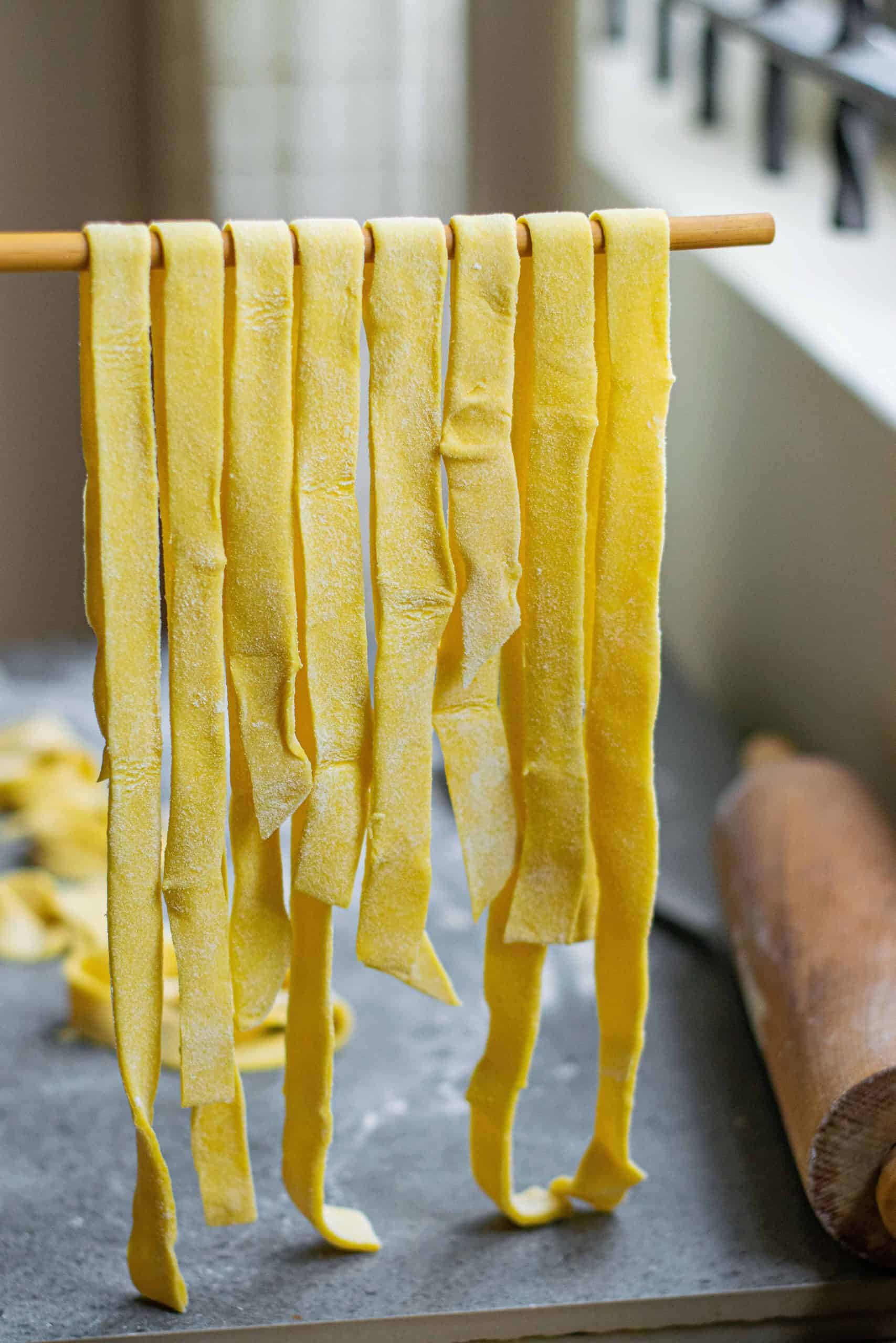 Pasta dough hanging on rack.