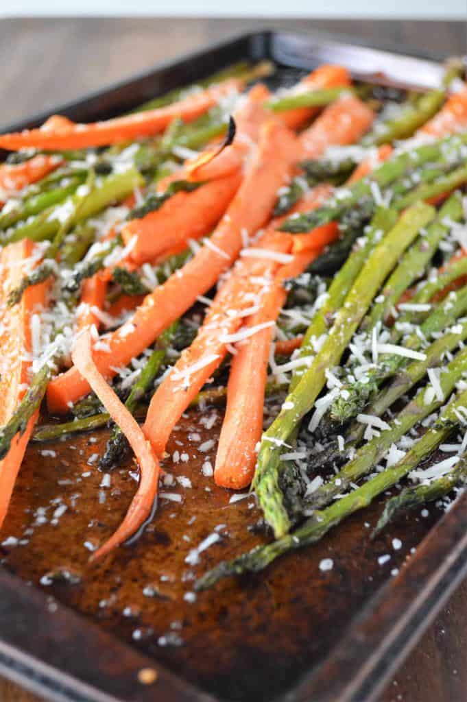 Roasted Asparagus and Carrots on a baking sheet with olive oil, salt, pepper and Parmesan cheese.