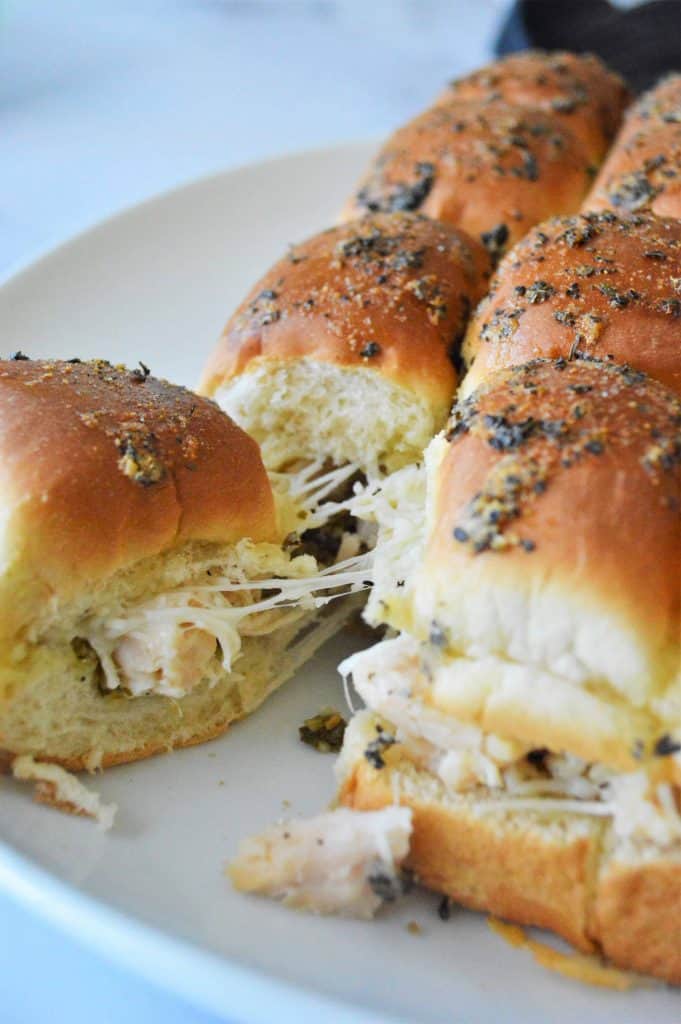 Chicken sliders being pulled apart on a white plate.