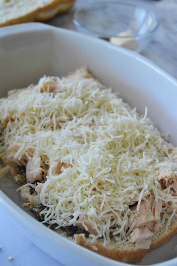 Shredded cheese on top of chicken and pesto rolls.