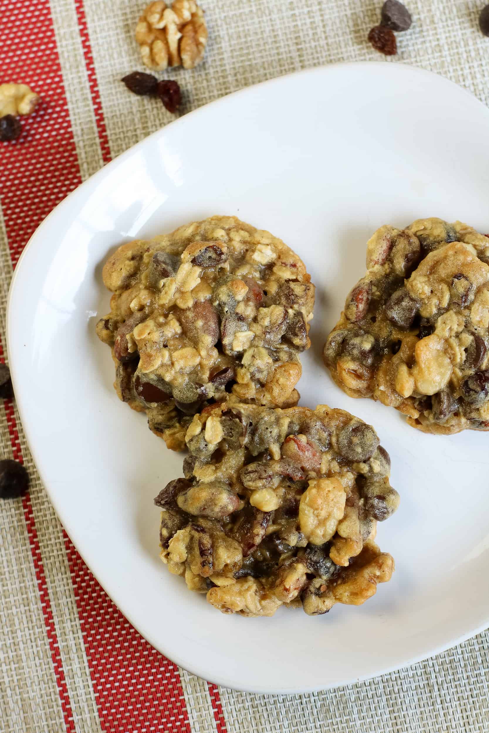Overhead view of trail mix cookies on a white plate.