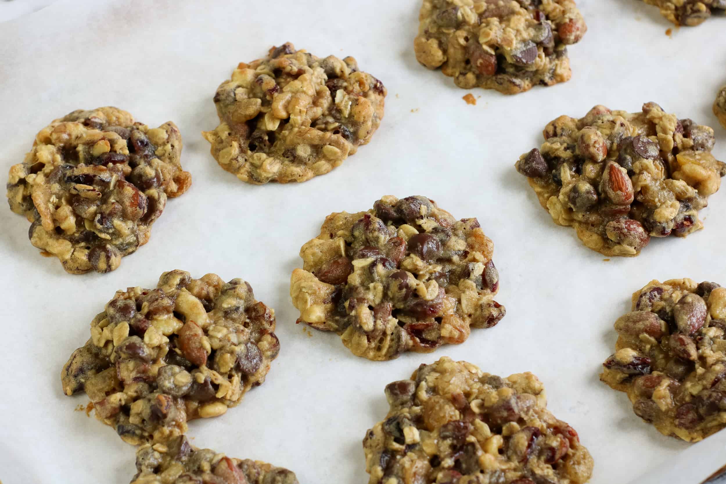 Baked Trail Mix Cookies on parchment line baking sheet.