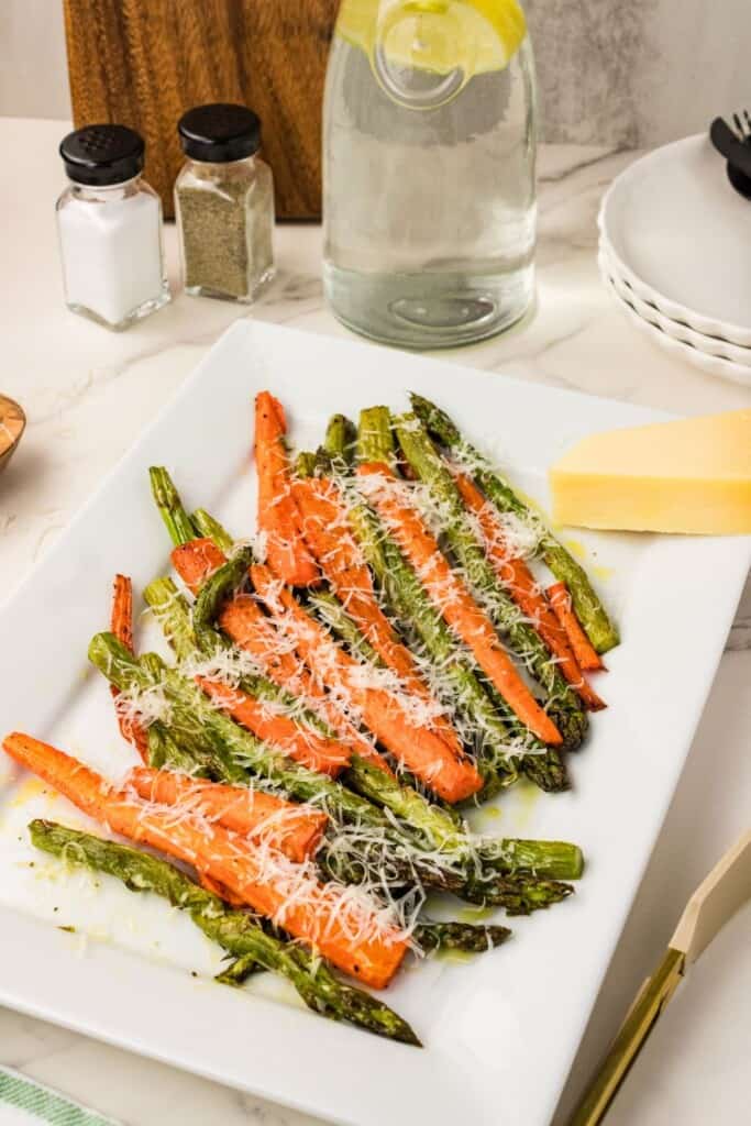 Asparagus and carrots with parmesan on a white  plate