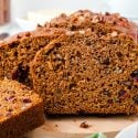 Head-on photo of pumpkin bread slices on a cutting board.