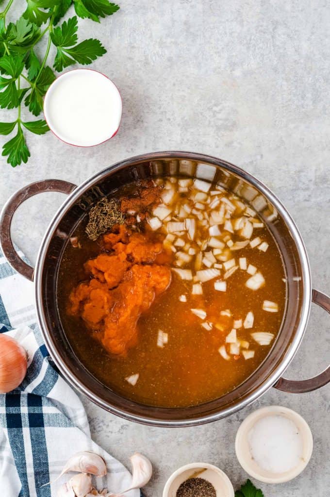 pot with vegetable broth, pumpkin puree and dice onion.