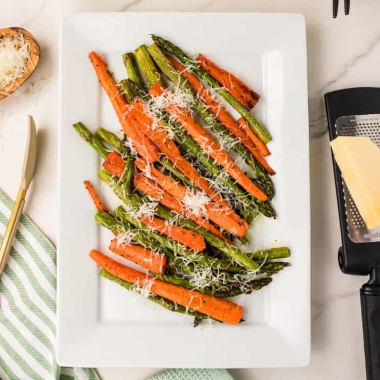 Roasted asparagus and carrots with Parmesan on a white plate, easy 5-ingredient side dish.