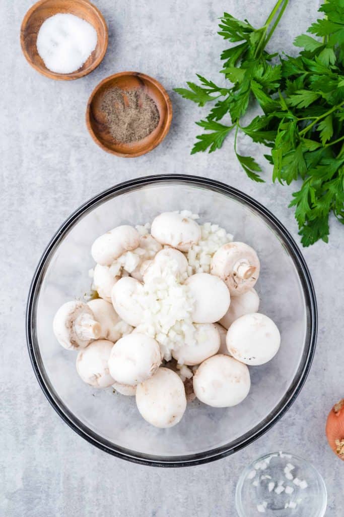 White mushrooms in a glass bowl.