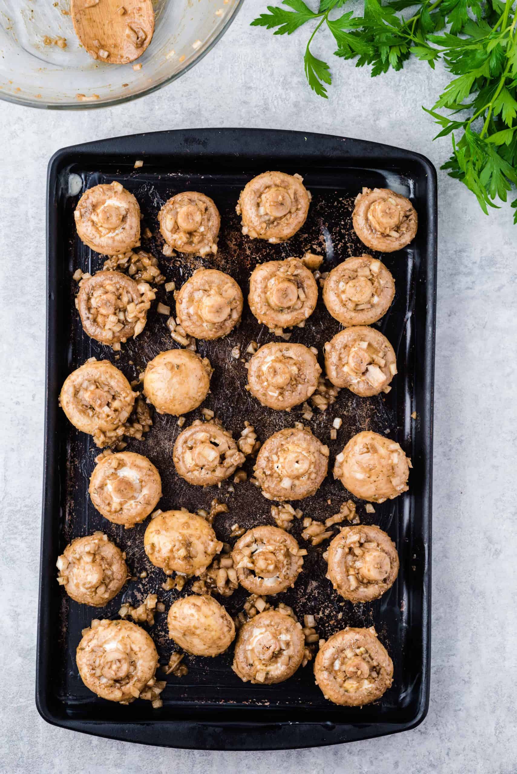 Coated mushrooms on a baking sheet.