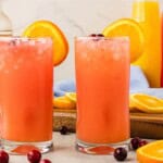 Two Madras cocktails served in tall glasses with vodka, cranberry juice, and orange juice