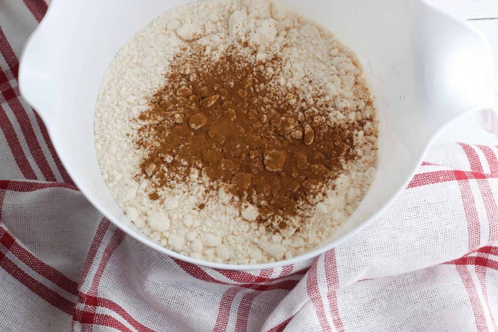 Cake mix, cinnamon, nutmeg, and allspice in a white bowl.