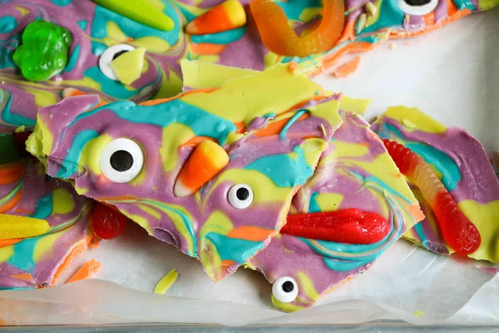 Witch's Brew Halloween Bark broken into pieces on baking sheet.