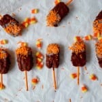 Milk chocolate and white chocolate dipped ice Krispies with orange sprinkles.