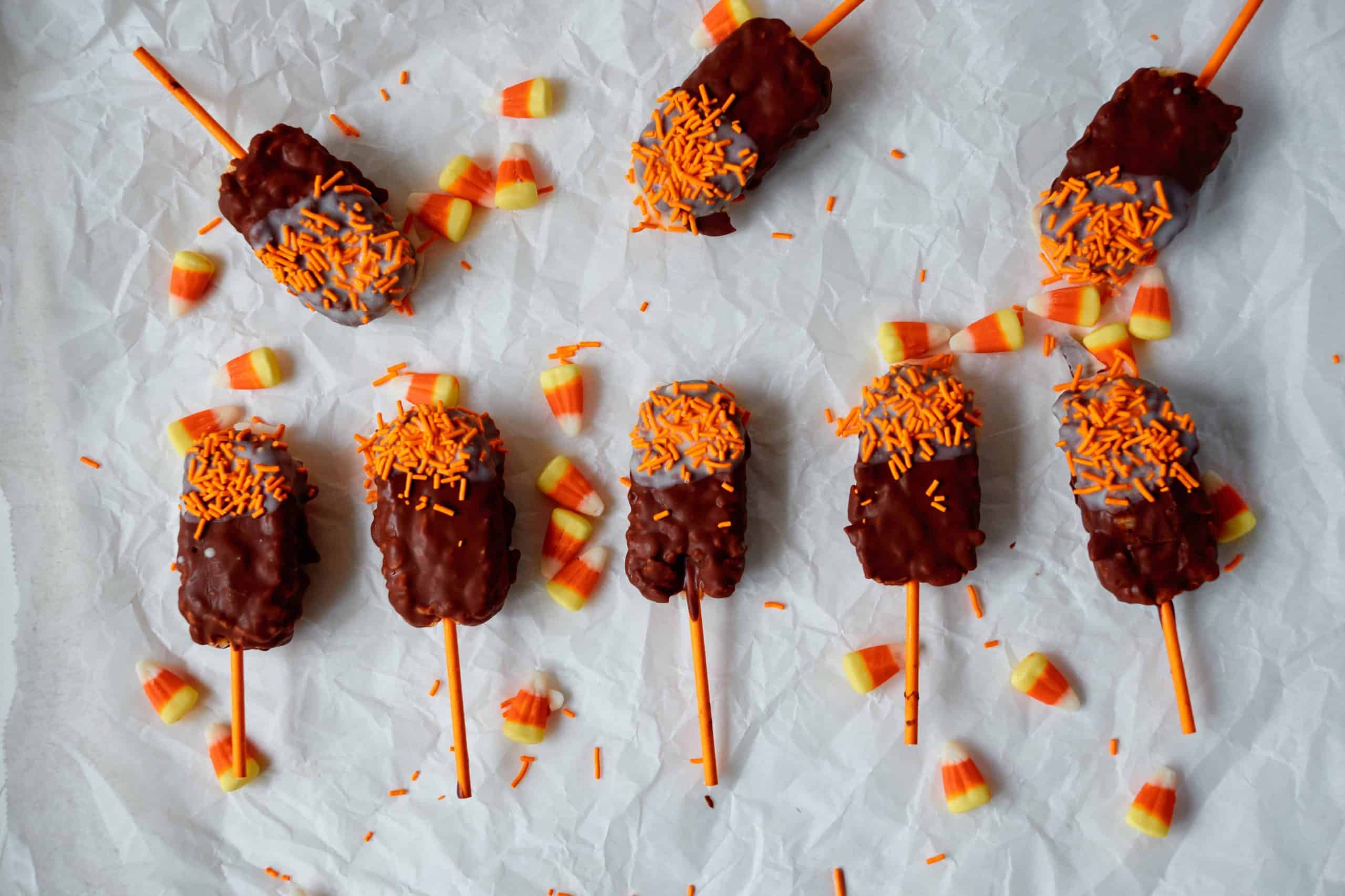 Milk chocolate and white chocolate dipped ice Krispies with orange sprinkles.