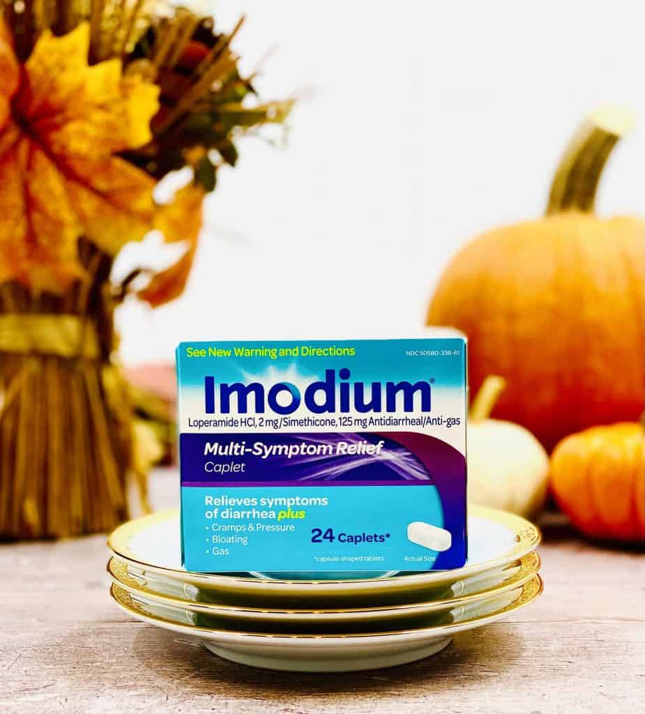 Closeup of box of Immodium with pumpkins and dried fall flowers in the background.