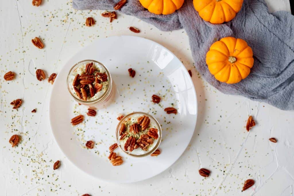 Breakfast oats with pecans on a white plate.