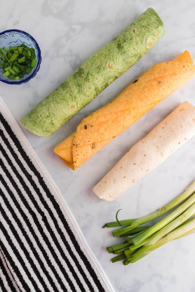 Rolled up tortillas on a white surface.
